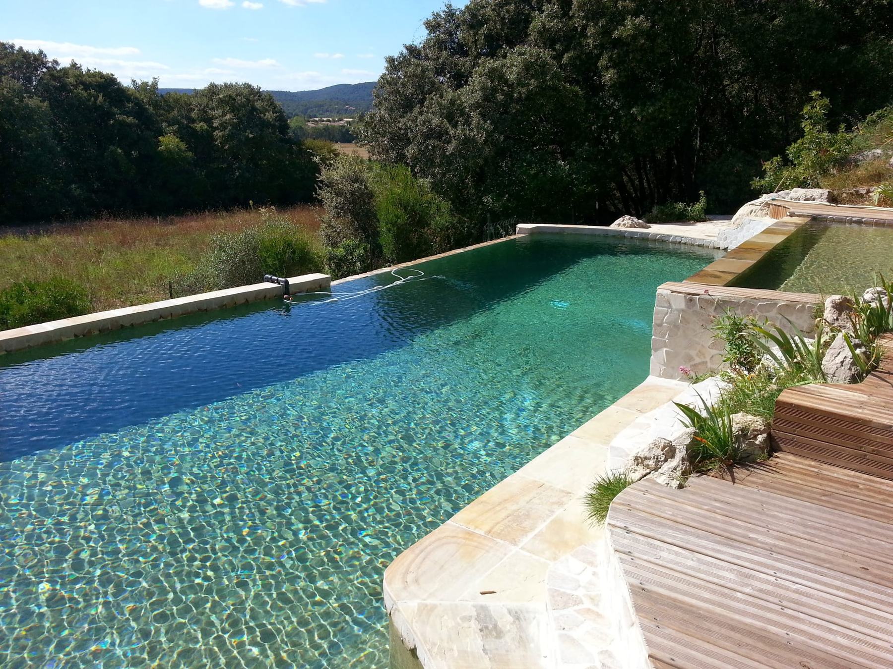 Piscine à débordement avec vue sur la vallée, réalisée par Naït Pool Services